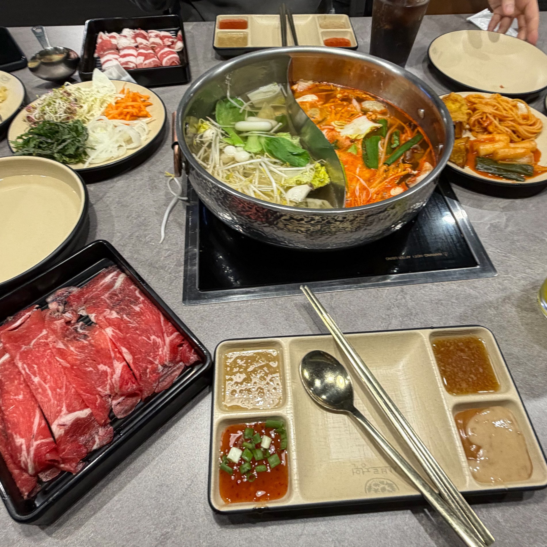 샤브르정원 발산역점 원앙냄비와 고기, 월남쌈 채소가 놓인 식탁
