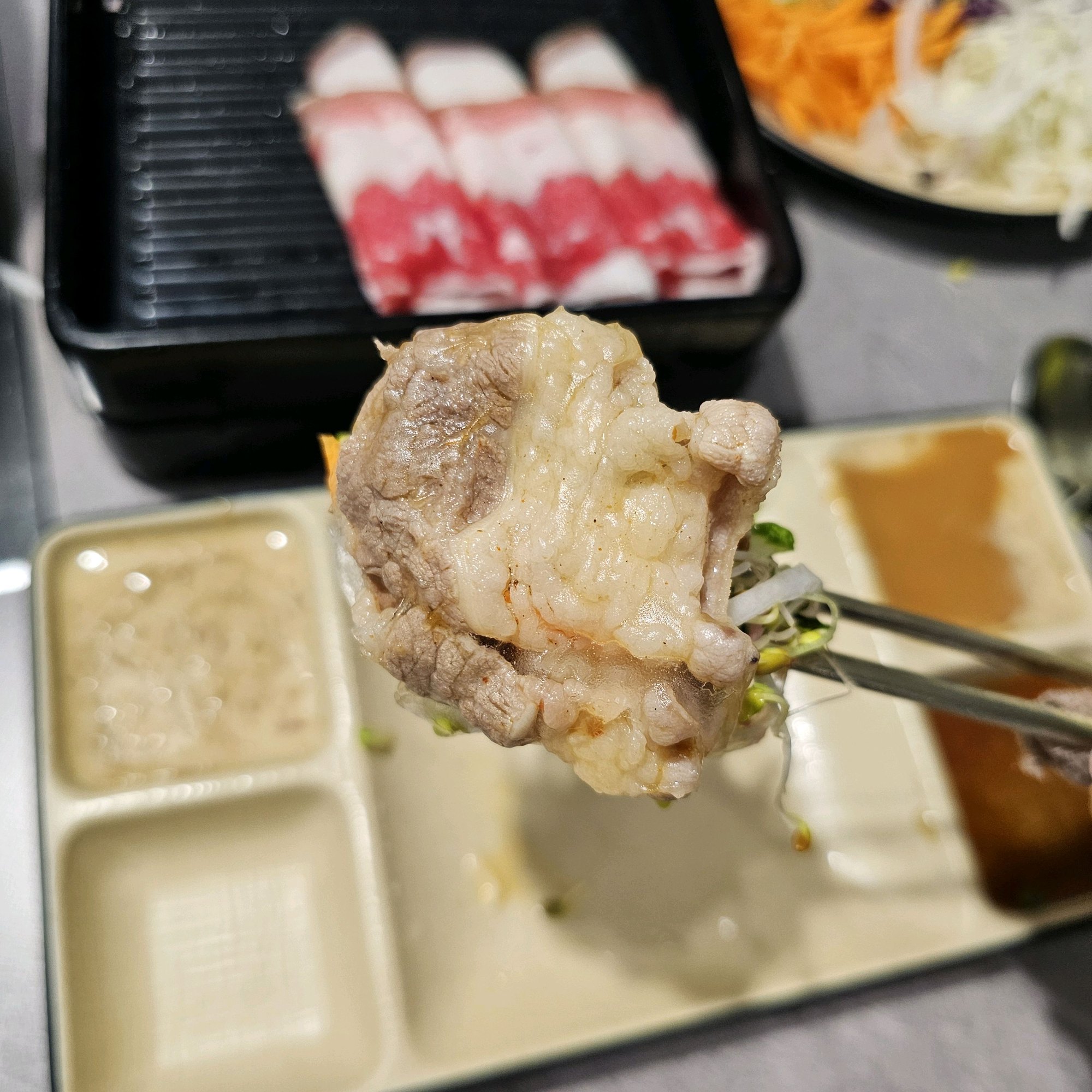 샤브르정원 발산역점에서 잘 익은 소고기와 채소를 함께 집은 한입