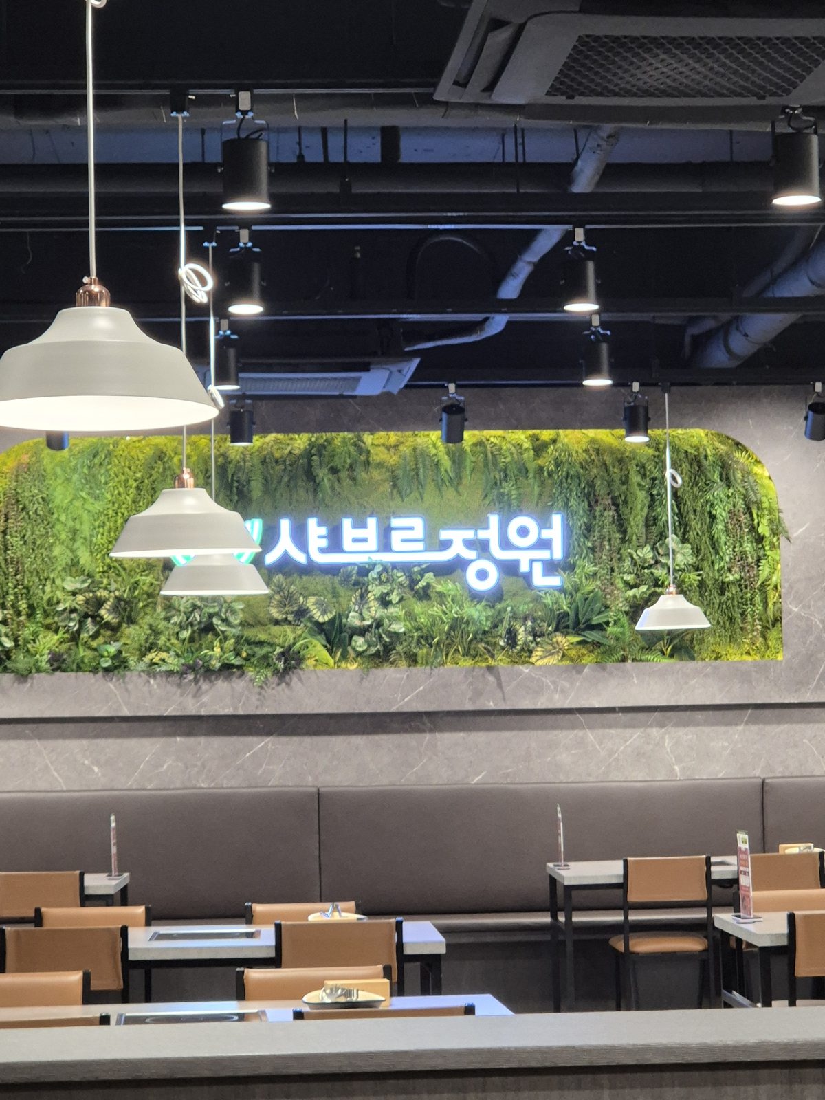 샤브르정원 발산역점 정원 벽과 좌석이 보이는 깔끔한 매장 내부