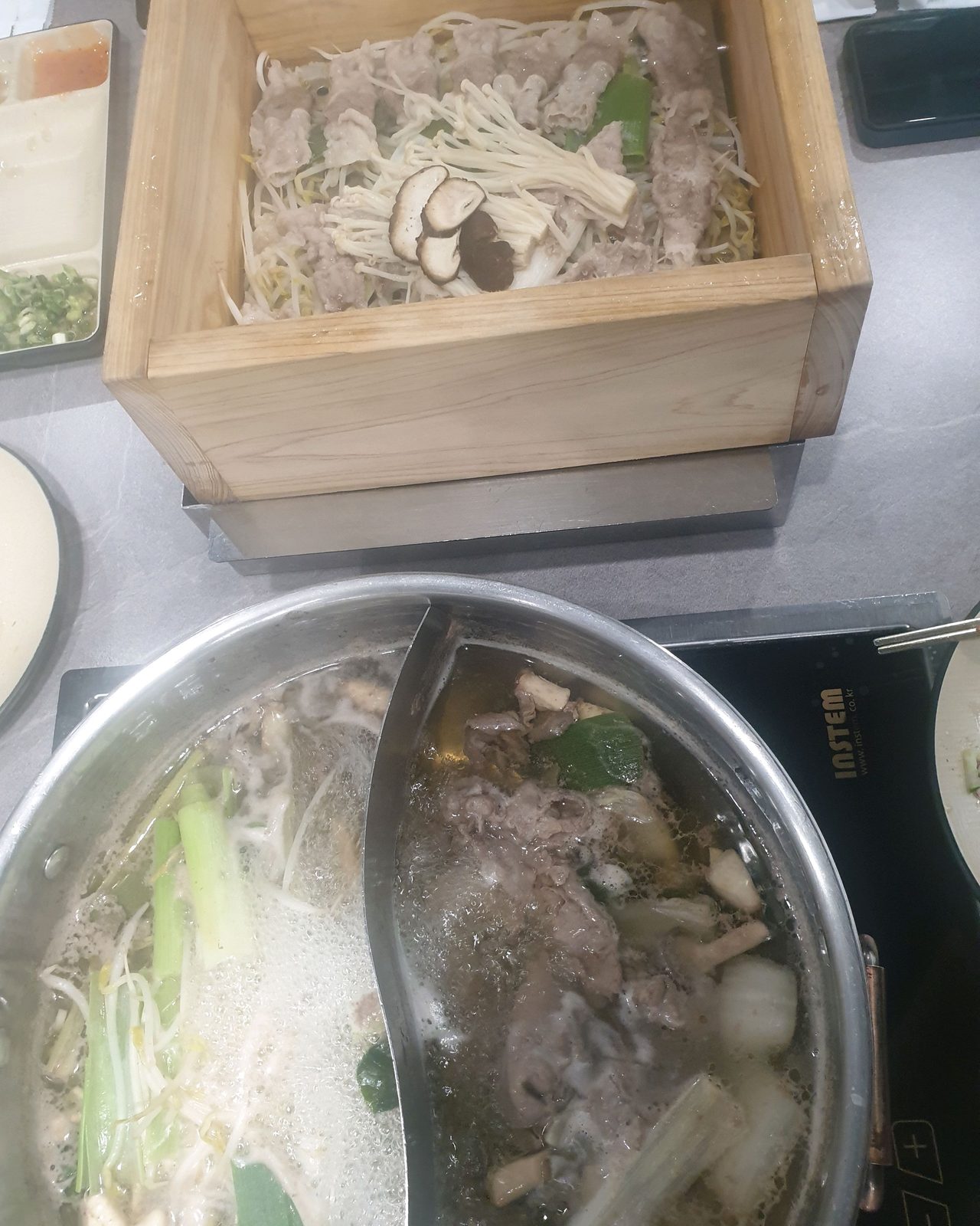 샤브르정원 발산역점 편백찜과 원앙냄비 고기가 함께 놓인 가족 식탁