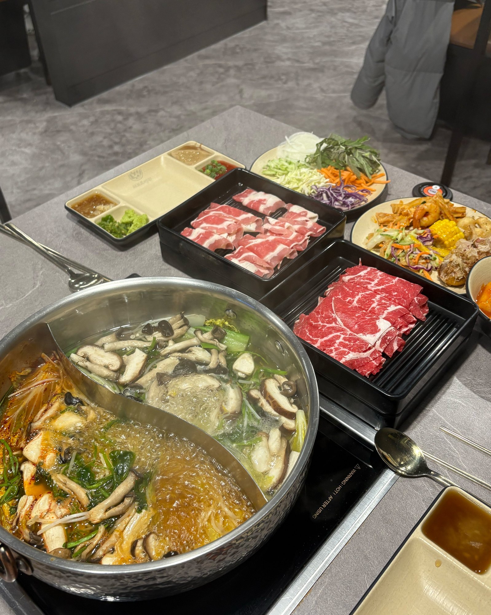 샤브르정원 발산역점 원앙냄비와 소고기 채소 접시가 놓인 점심 테이블