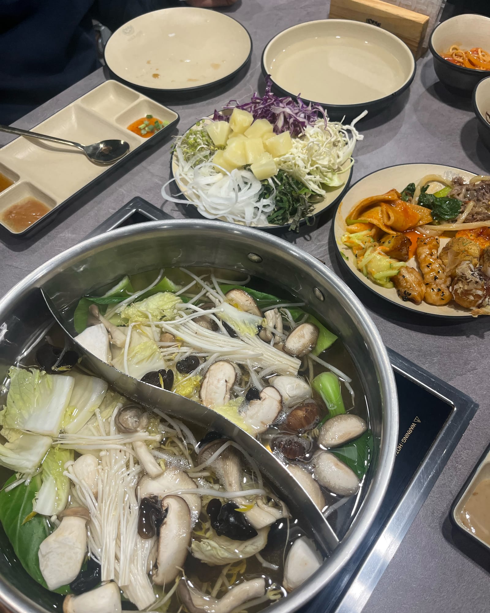 샤브샤브 재방문 식탁의 원앙냄비와 익힌 버섯 채소